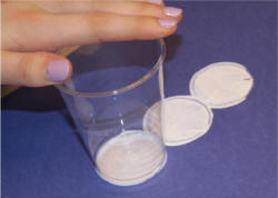 Dip the bottom of the cup in white paint and press it onto the paper.