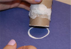 Dip one end of toilet paper roll in white paint and press onto the paper.